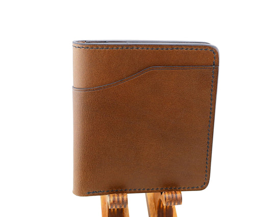 Brown leather wallet on a wooden stand against a white background