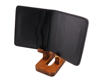 Black bifold wallet on a wooden stand against a white background