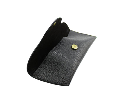 Black leather eyewear case with a gold magnetic button on a light gray background