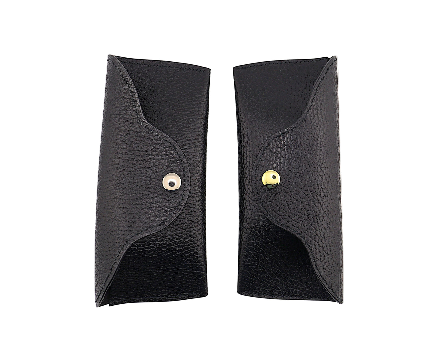 Two black leather cases with gold and silver buttons on a white background