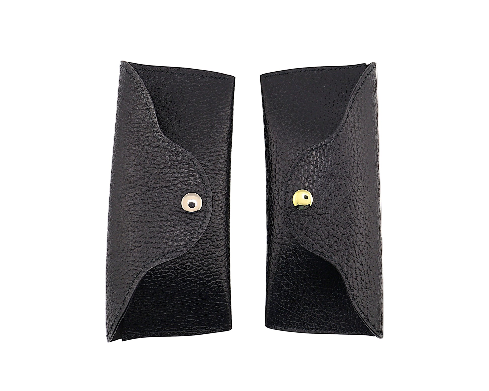 Two black leather cases with gold and silver buttons on a white background