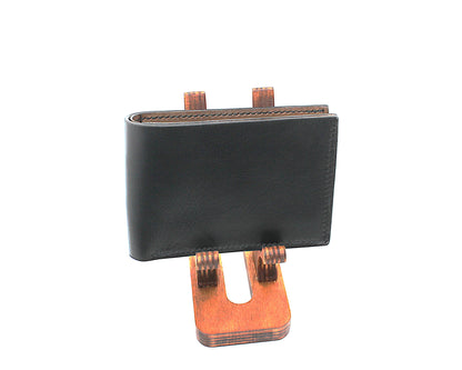 Black leather wallet on a wooden stand against a white background