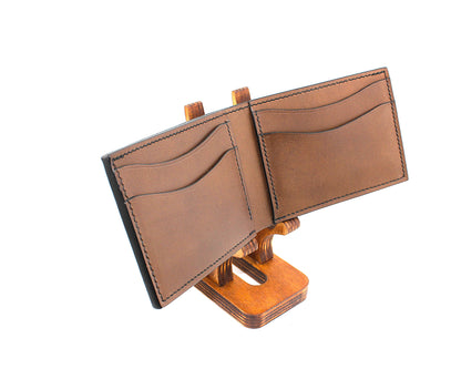 Brown leather wallet on a wooden stand against a white background