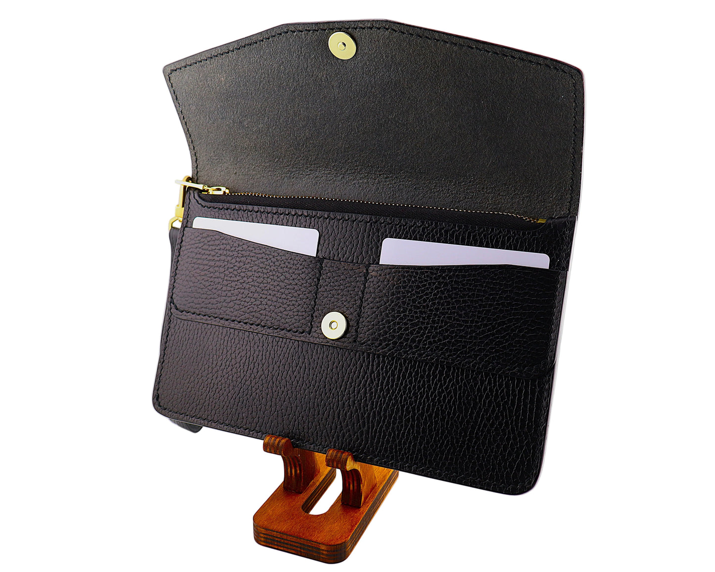 Black leather clutch wallet on a wooden stand against a white background