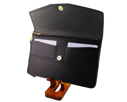 Black leather clutch wallet on a wooden stand against a white background