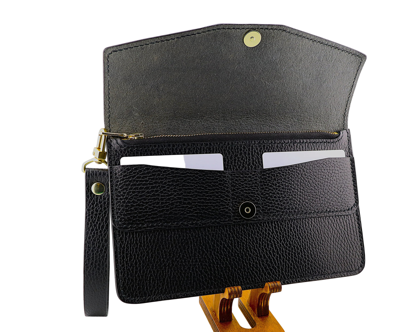 Black leather clutch bag on a wooden stand against a white background