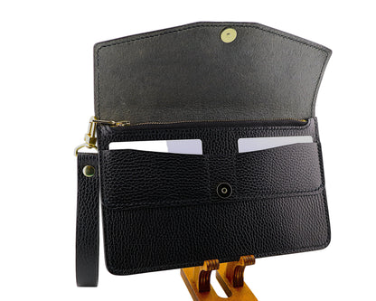 Black leather clutch bag on a wooden stand against a white background
