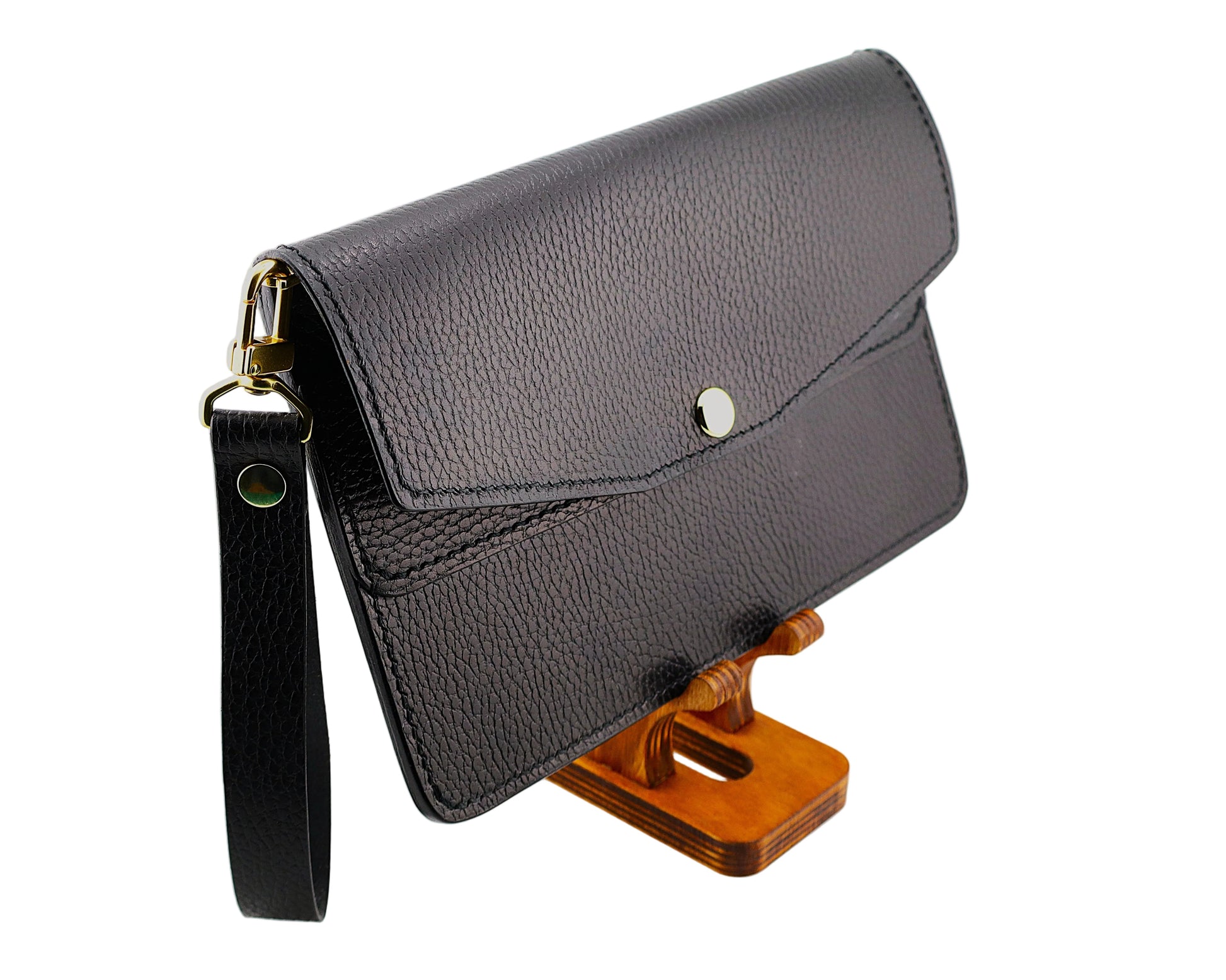 Black leather clutch bag on a wooden stand against a white background