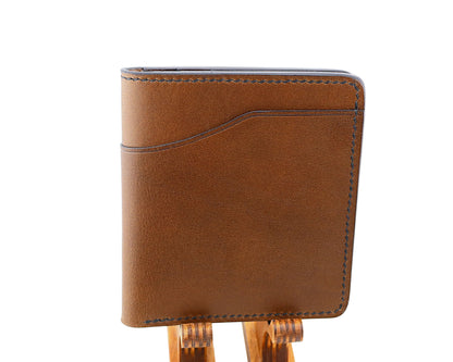 Brown leather wallet on a wooden stand against a white background