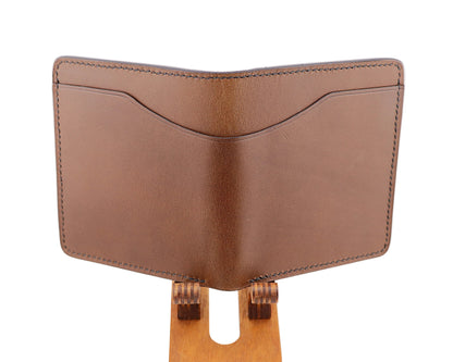 Brown leather wallet on a wooden stand against a light gray background