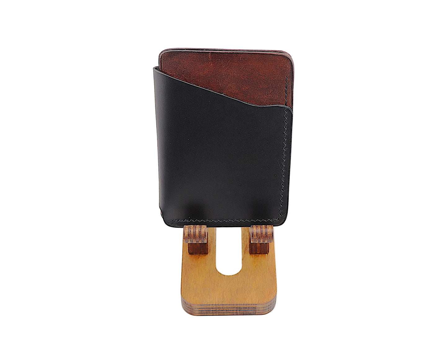 Black and brown leather wallet with wooden stand on a white background