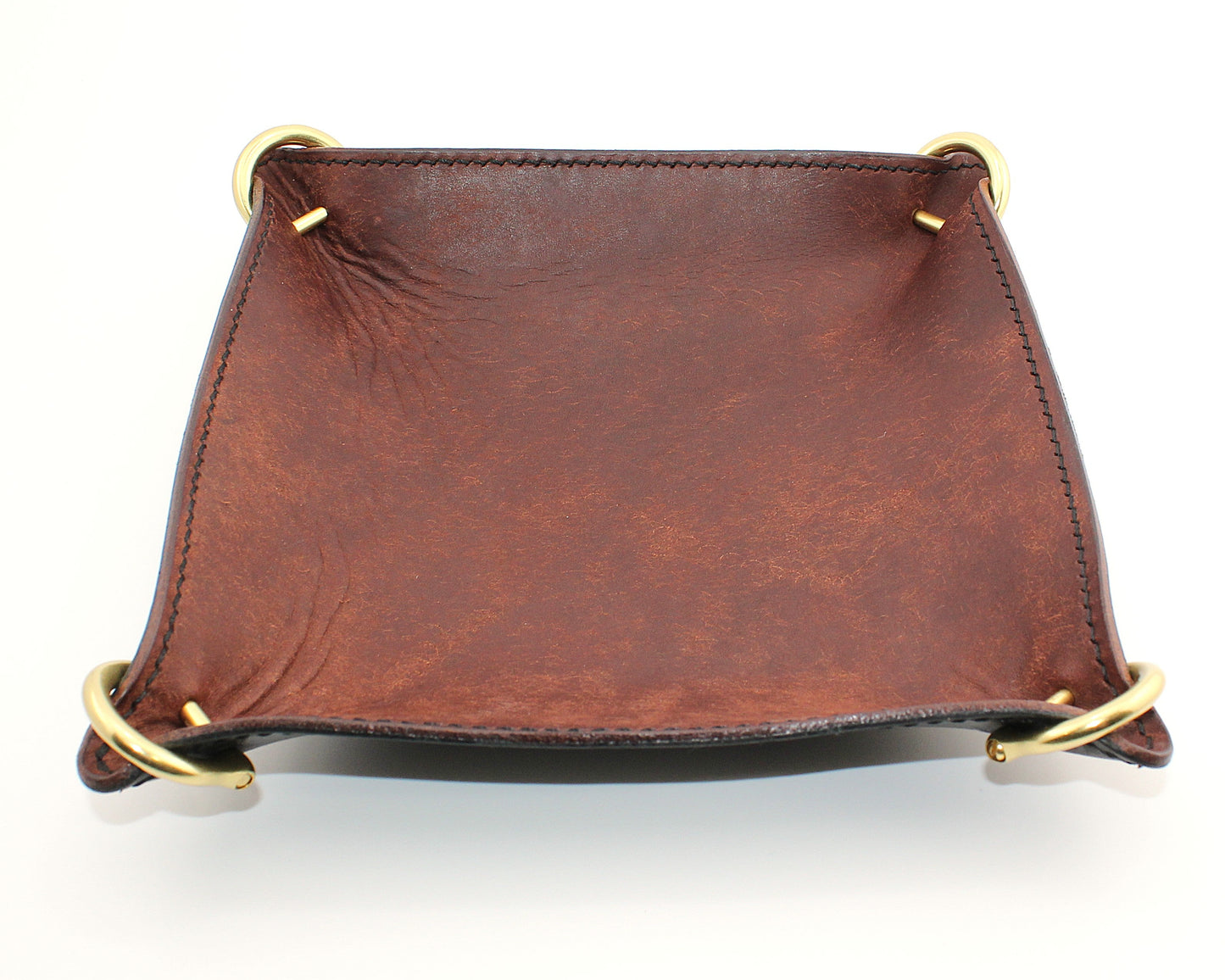 Brown leather tray with gold accents on a white background