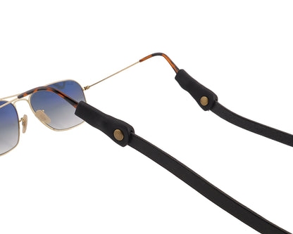 Sunglasses with a black strap on a light gray background