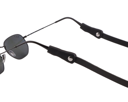 Sunglasses with a black strap on a light gray background